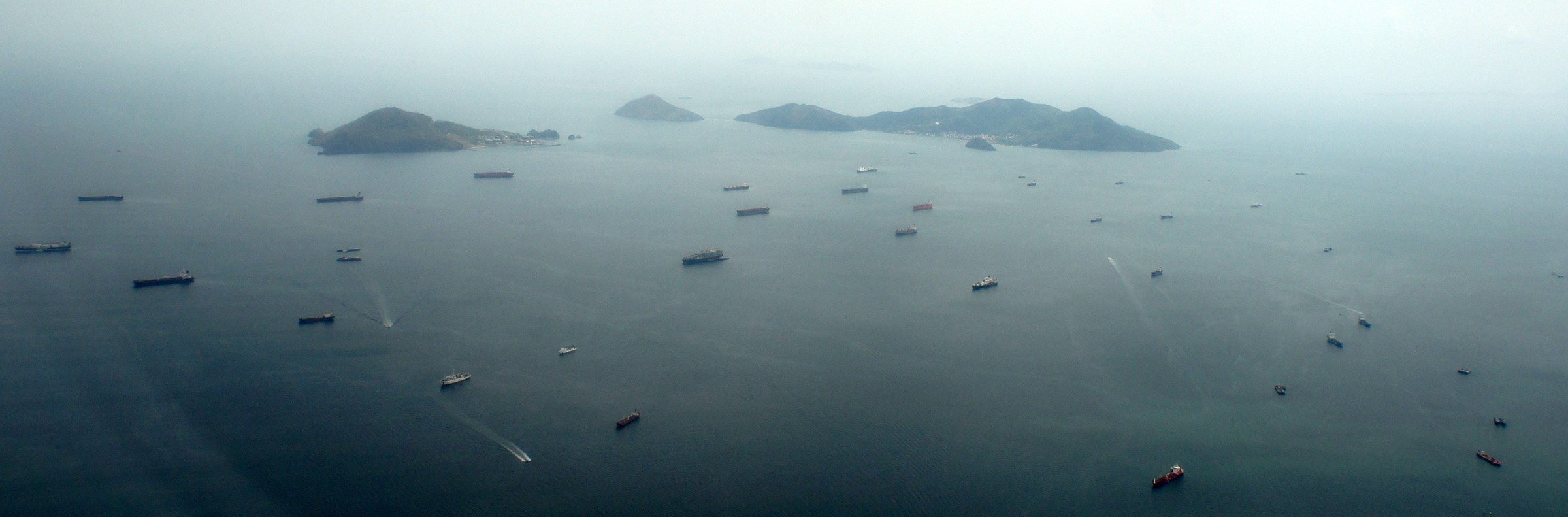 Dozens of cargo ships anchored at the Pacific entrance of the Panama Canal, waiting to transit